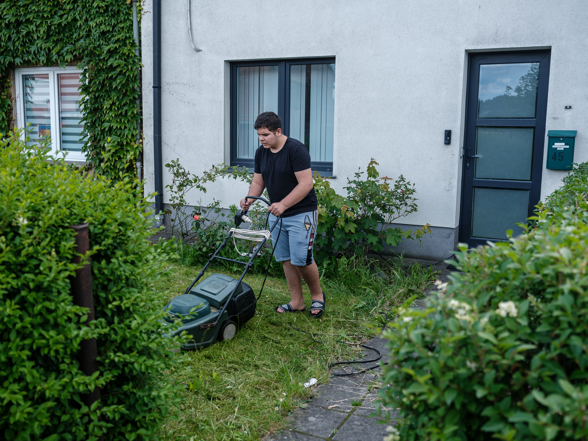Ionuț tunde iarba din fața casei lui din La Louvière, Belgia, iunie 2024 Ionuț tunde iarba din fața casei lui din La Louvière, Belgia, iunie 2024