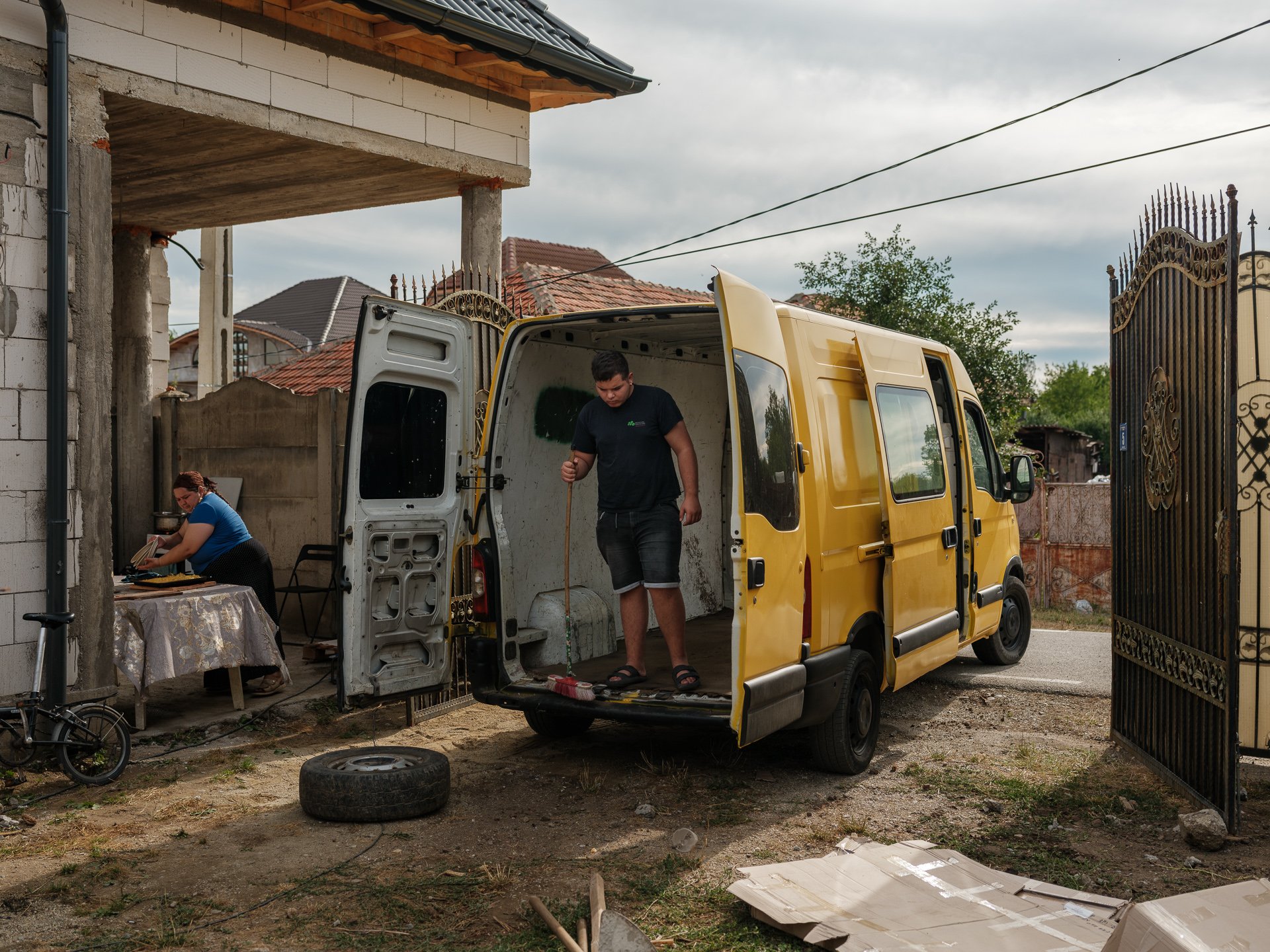 Ionuț mătură duba după ce au cărat materiale de construcții. Corcova, România, iulie 2025 Ionuț mătură duba după ce au cărat materiale de construcții. Corcova, România, iulie 2025