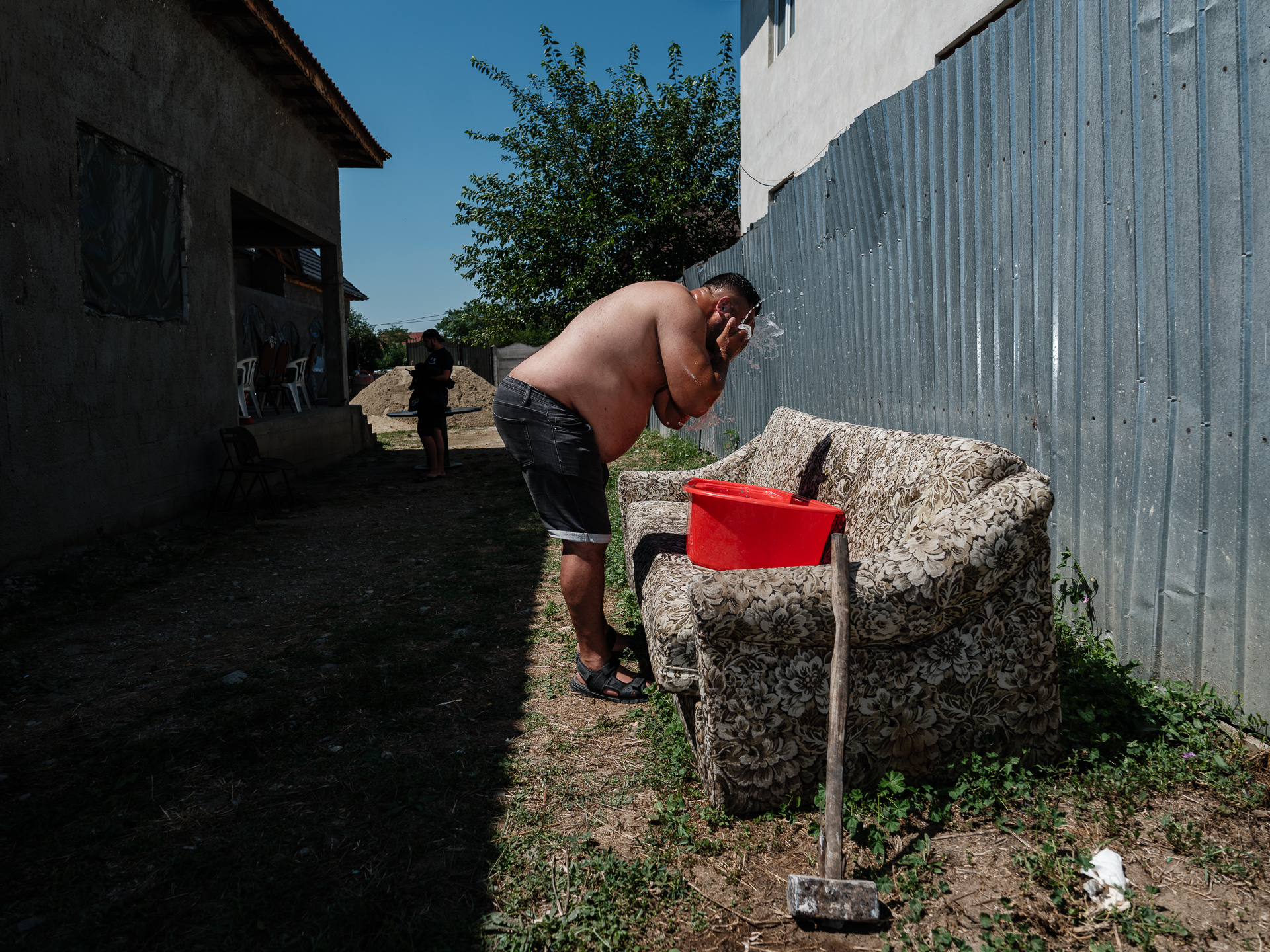 Geo se spală la lighean în curtea casei din Corcova, România, unde baia nu este încă terminată și satul nu are canalizare și apă curentă. August 2025 Geo se spală la lighean în curtea casei din Corcova, România, unde baia nu este încă terminată și satul nu are canalizare și apă curentă. August 2025