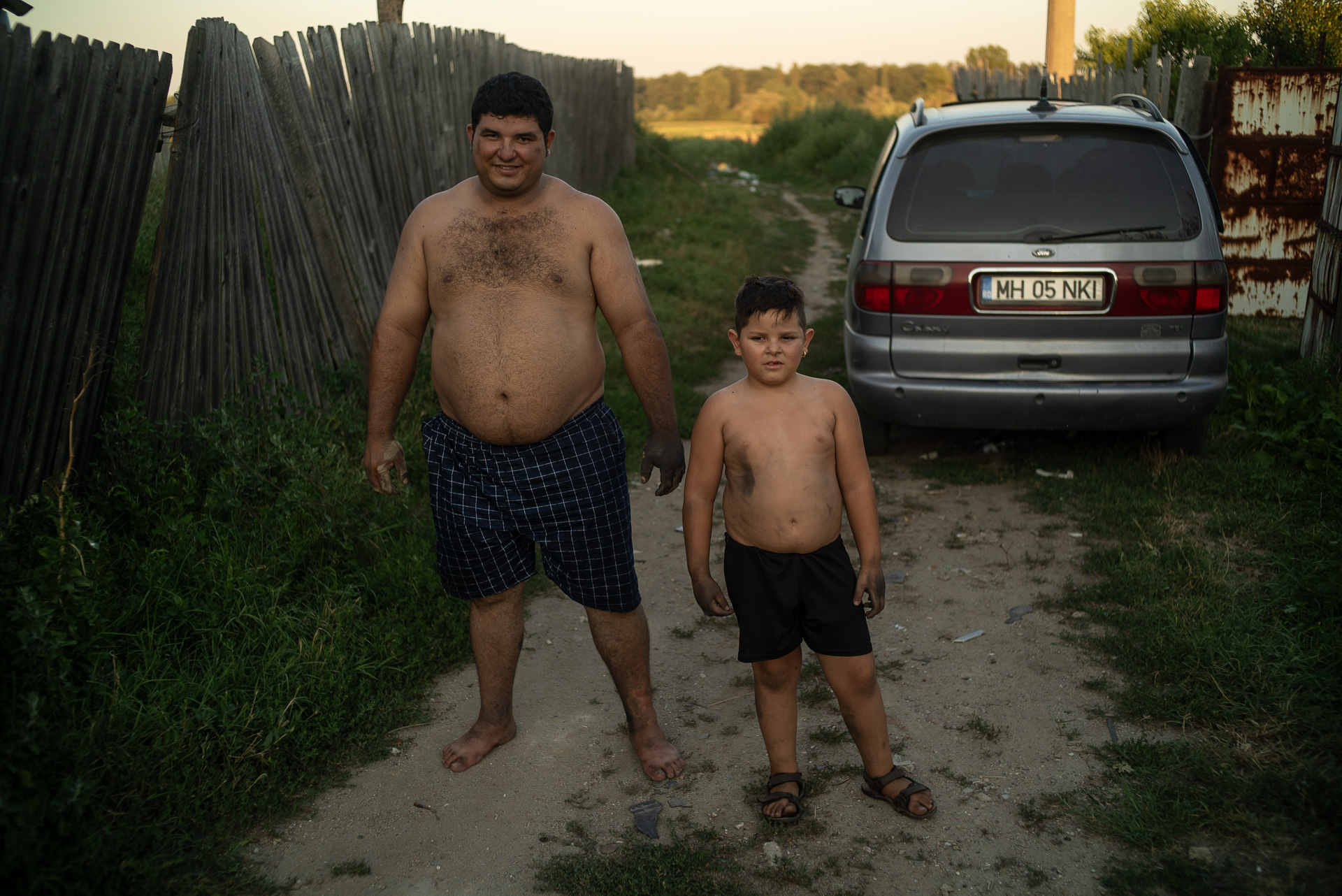 Geo și fiul său, Ionuț, lângă atelierul lui Ilie. Corcova, România, august 2017 Geo și fiul său, Ionuț, lângă atelierul lui Ilie. Corcova, România, august 2017