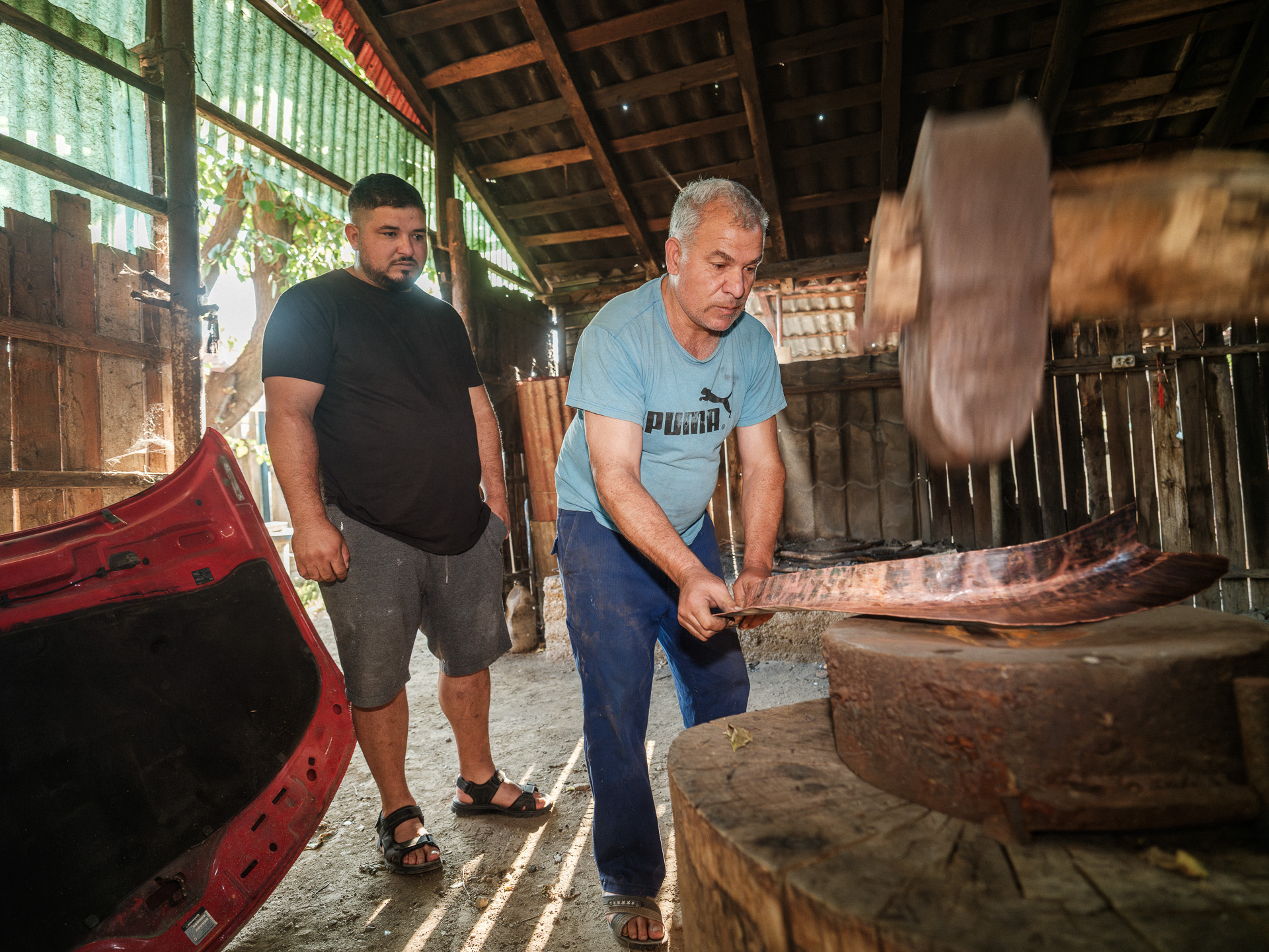 Geo îl ajută pe unchiul său, Cioabă, să facă un cazan de aramă. Corcova, România, august 2025 Geo îl ajută pe unchiul său, Cioabă, să facă un cazan de aramă. Corcova, România, august 2025