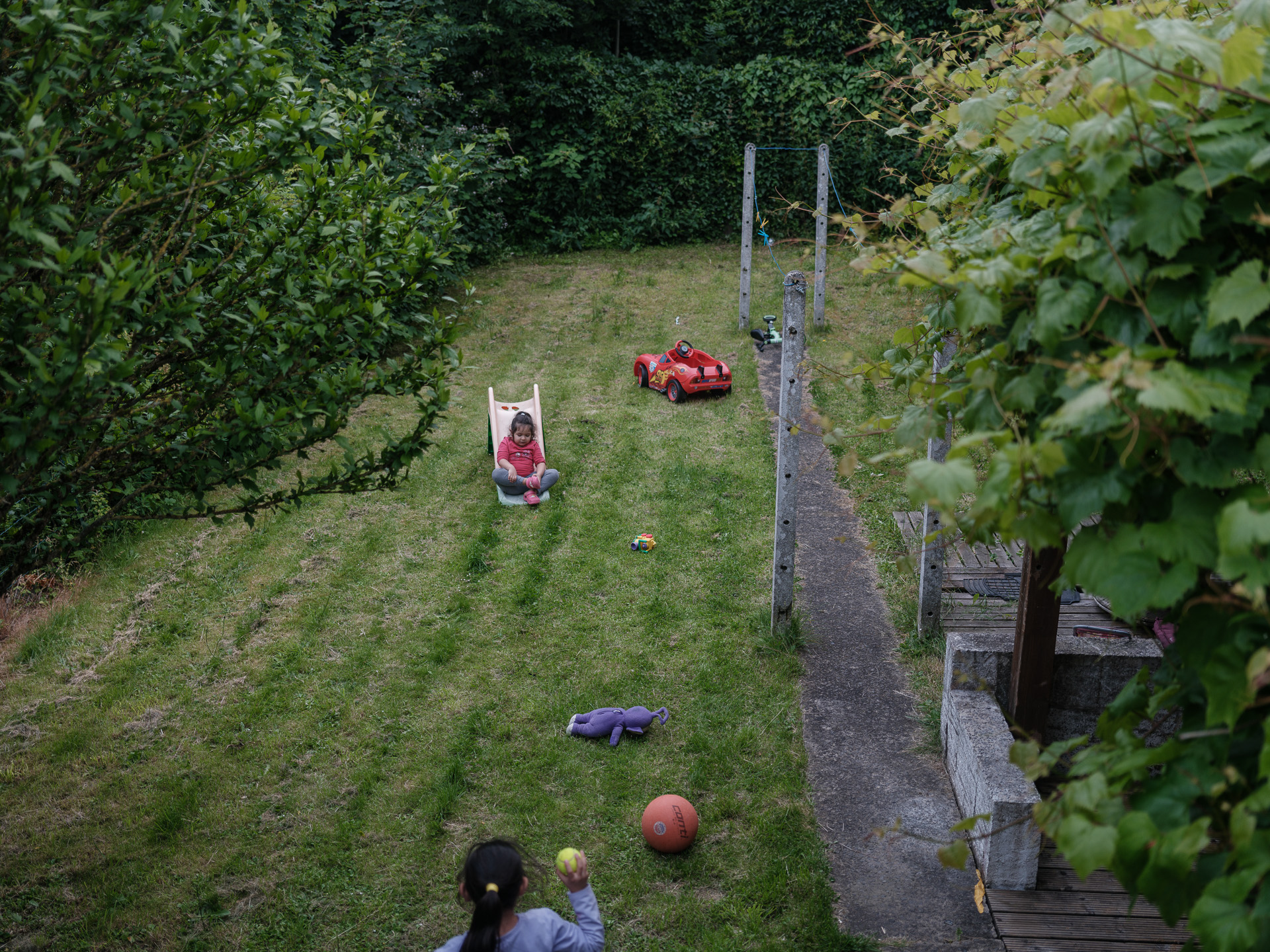 Maria și Andreea se joacă în curtea casei din La Louvière, Belgia, iunie 2024 Maria și Andreea se joacă în curtea casei din La Louvière, Belgia, iunie 2024