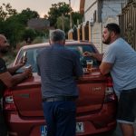 Alin, Cioabă și Geo beau bere în fața casei, Corcova, România, iulie 2025