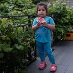 Andreea mănâncă pepene pe terasa casei din La Louvière, Belgia, iulie 2024